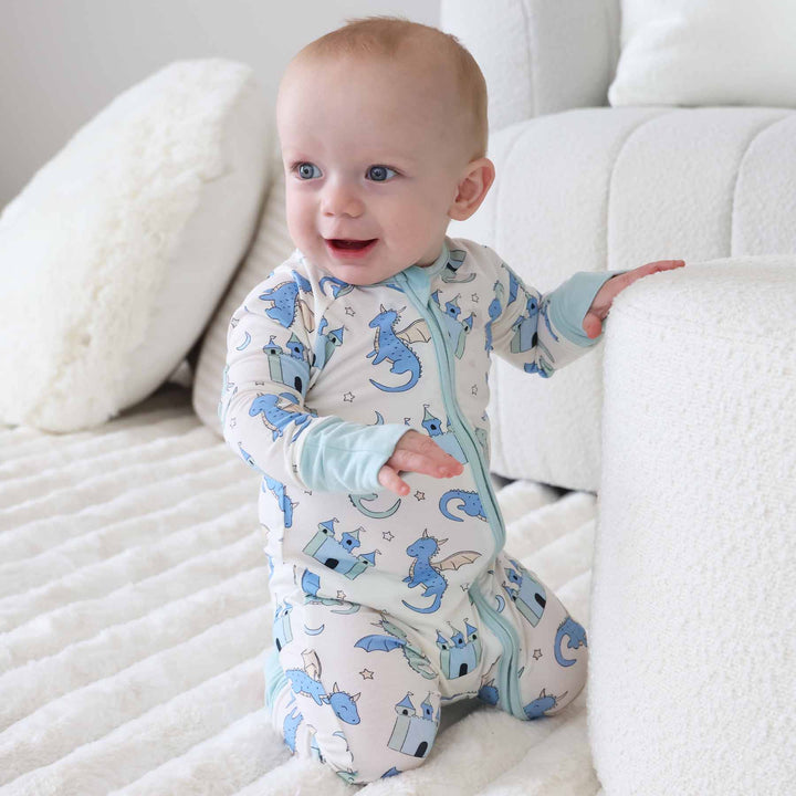 Infant boy wearing cream romper with dragon and mint trim accents