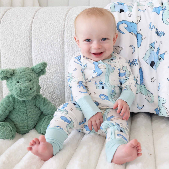 Infant in convertible romper with castles, dragons, and stars design