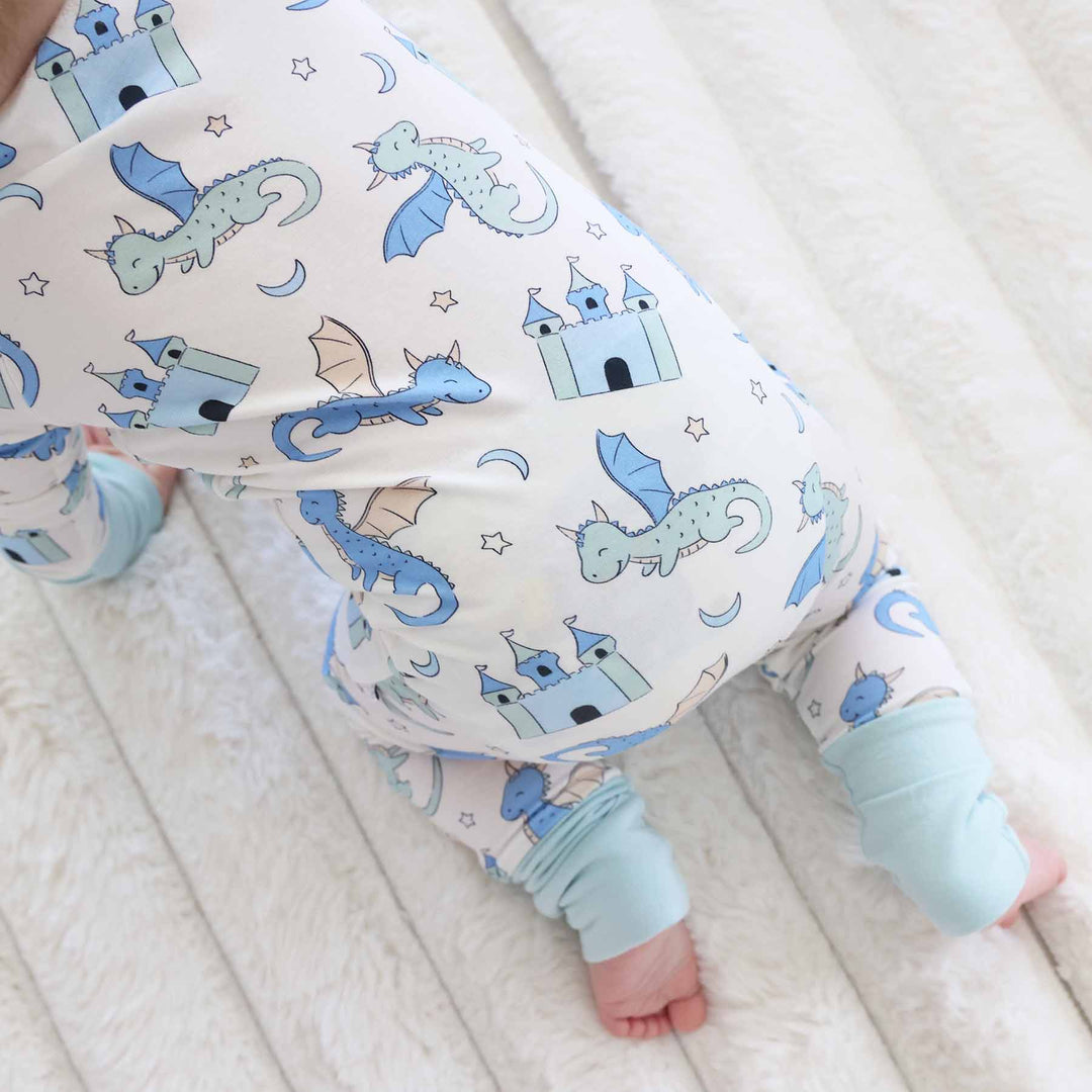 Baby crawling in dragon print outfit with two-way zipper detail