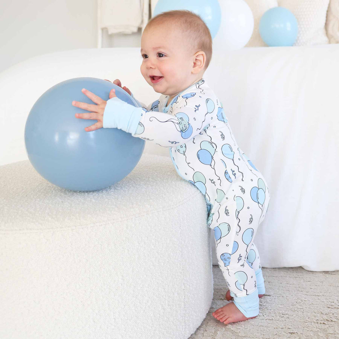 standing baby boy wearing blue party time convertible zip romper 