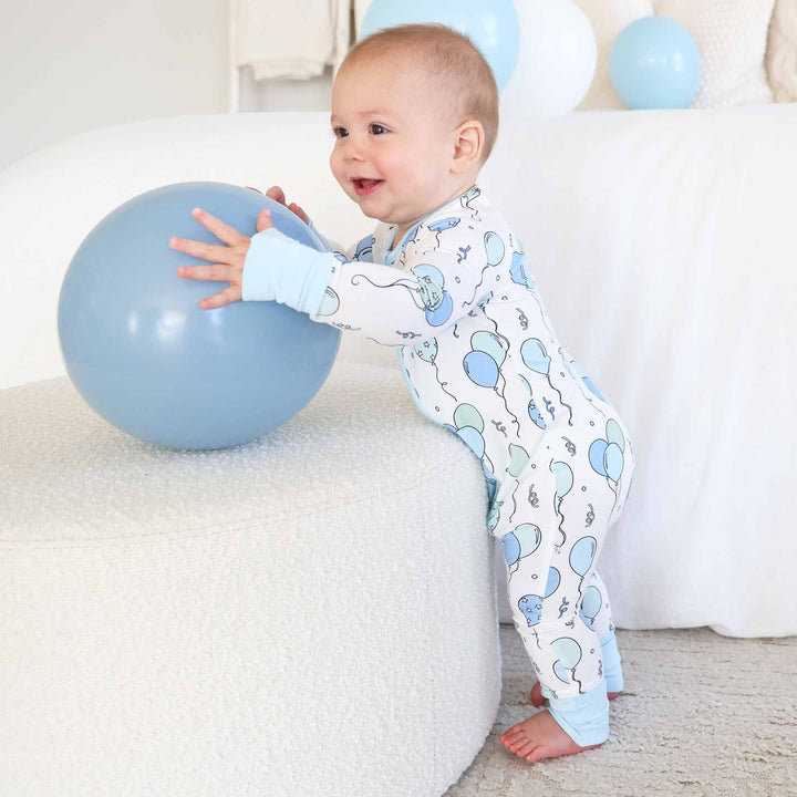standing baby boy wearing blue party time convertible zip romper 