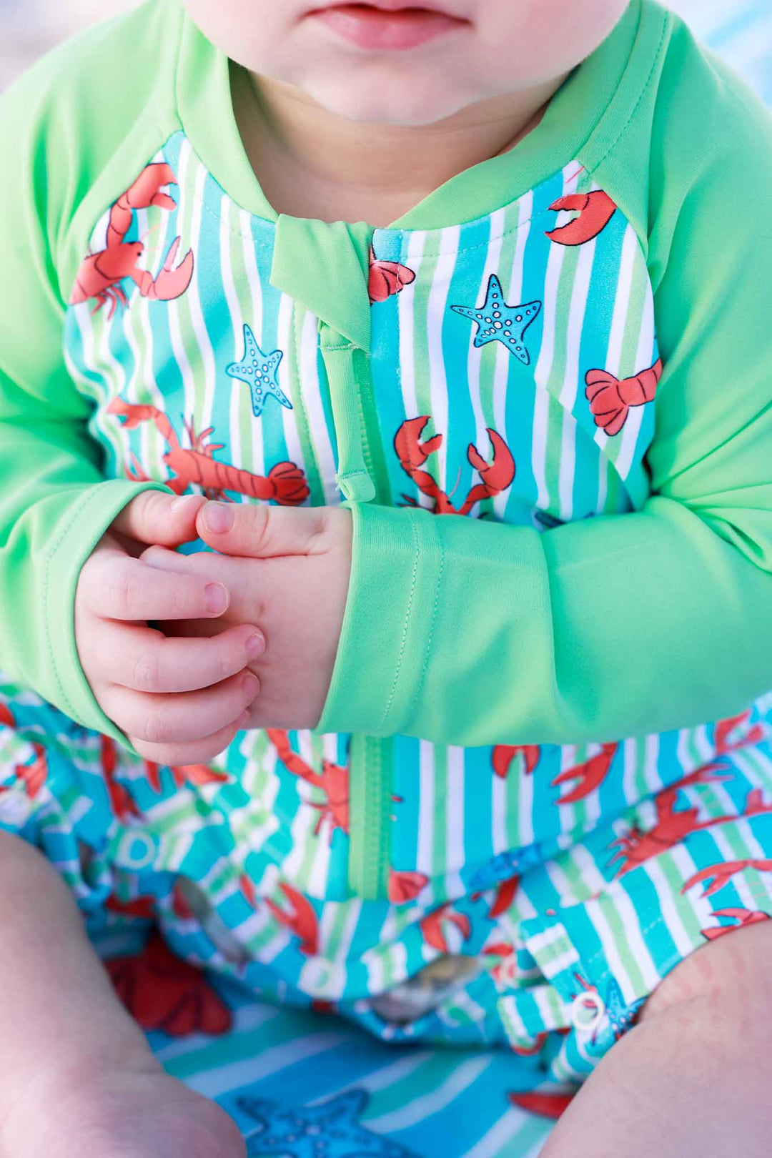 closeup of pinch me long sleeve rash guard swim romper shortie with lobsters