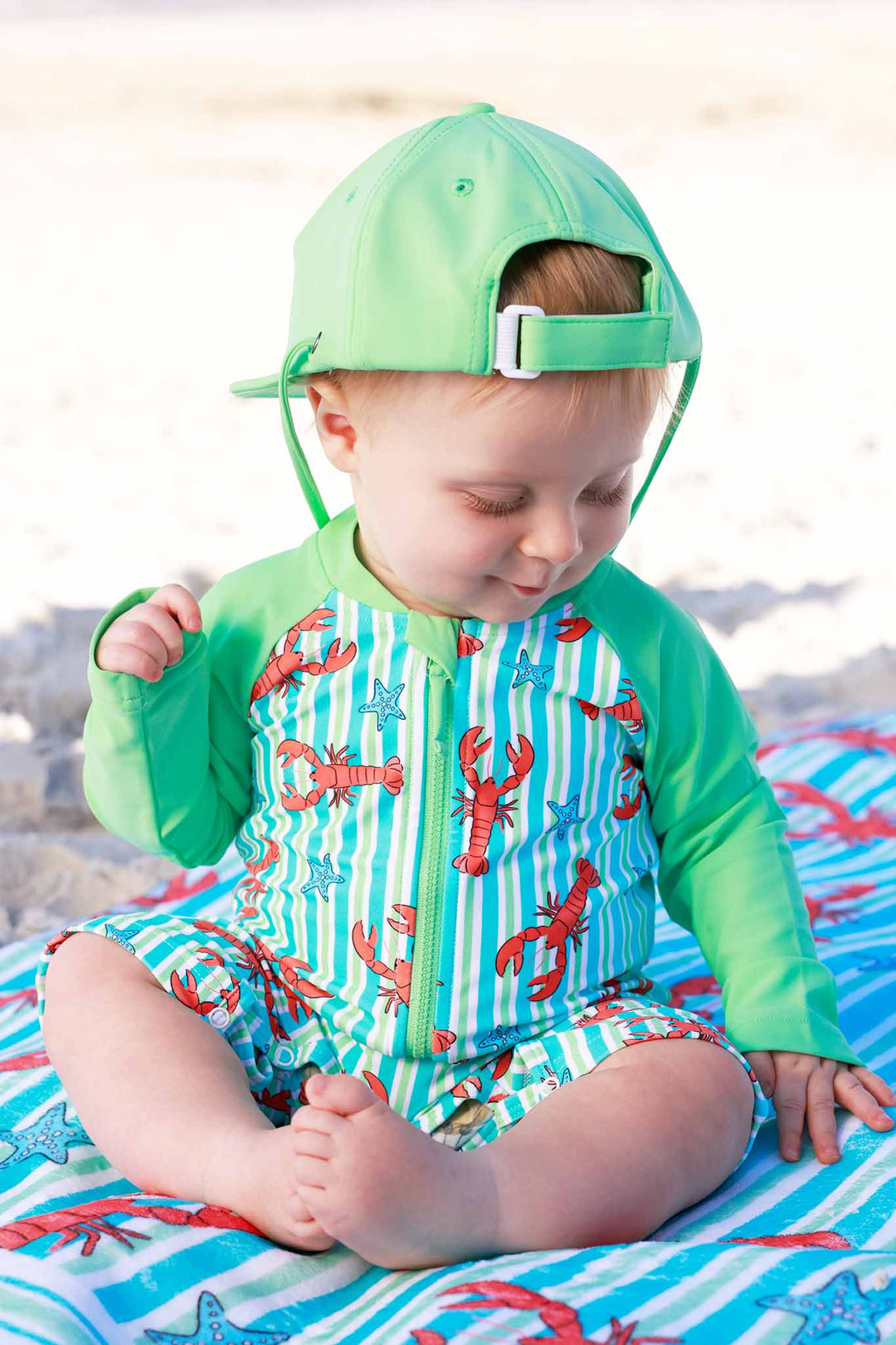 lobster shorty romper for boys with matching bright green surf hat 