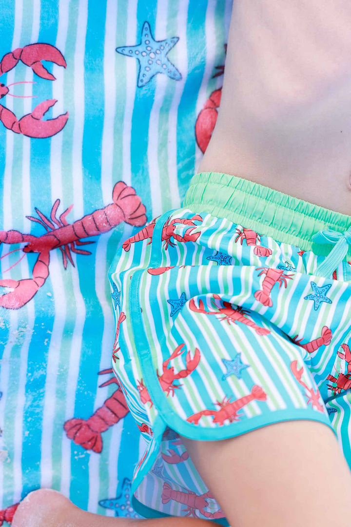 closeup of lobster swim trunks for boys with the matching towel