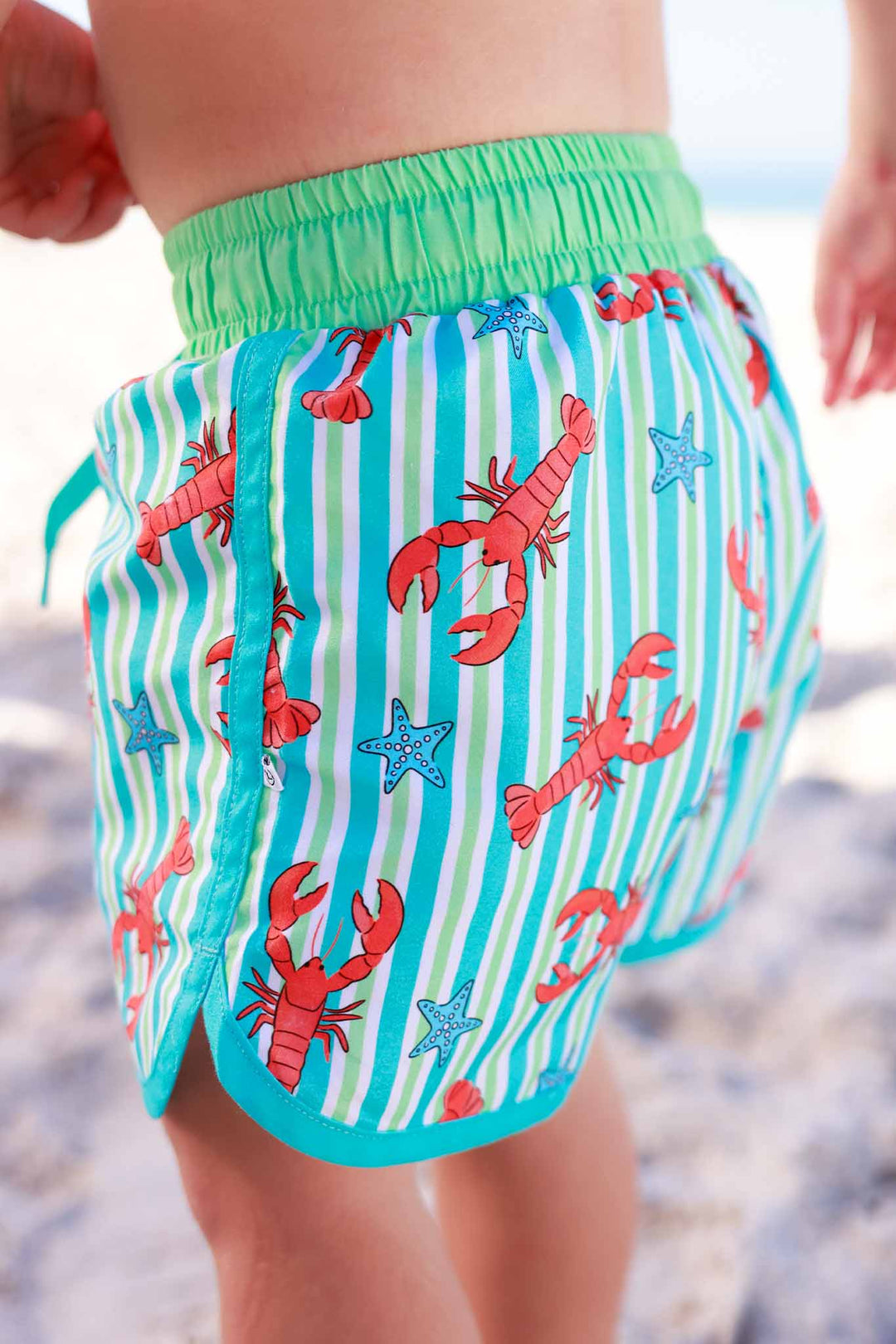 closeup of pinch me lobster swim trunks for boys 