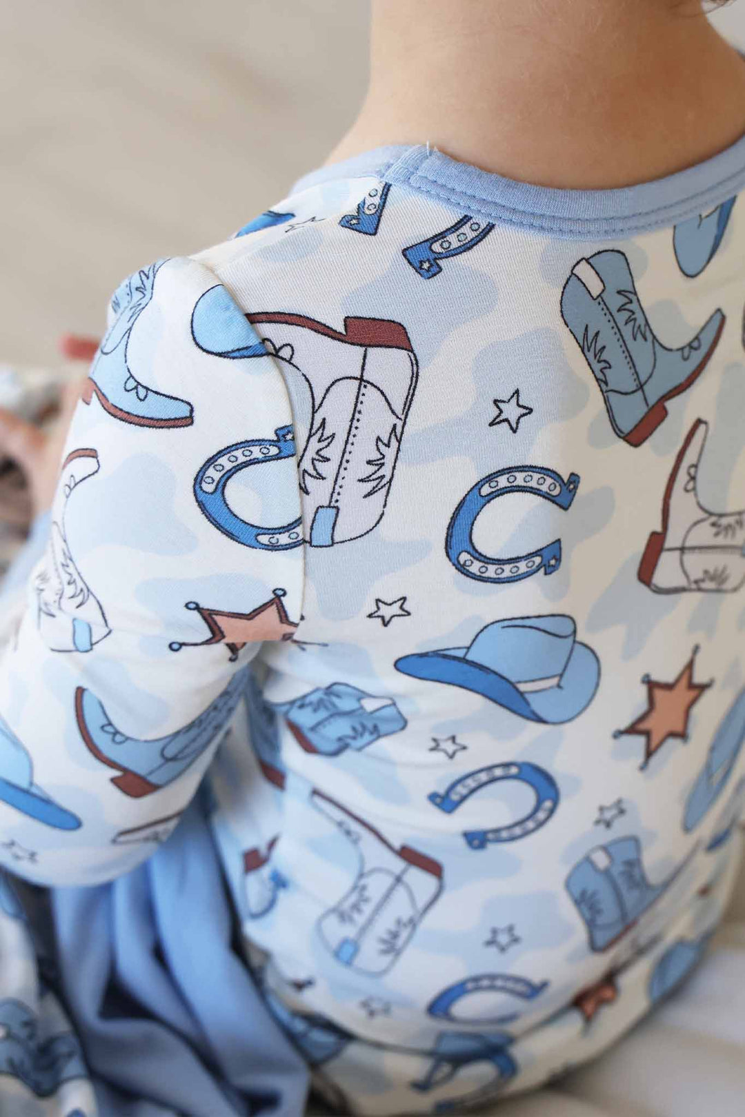 closeup of blue rodeo themed two piece pajama set for boys 