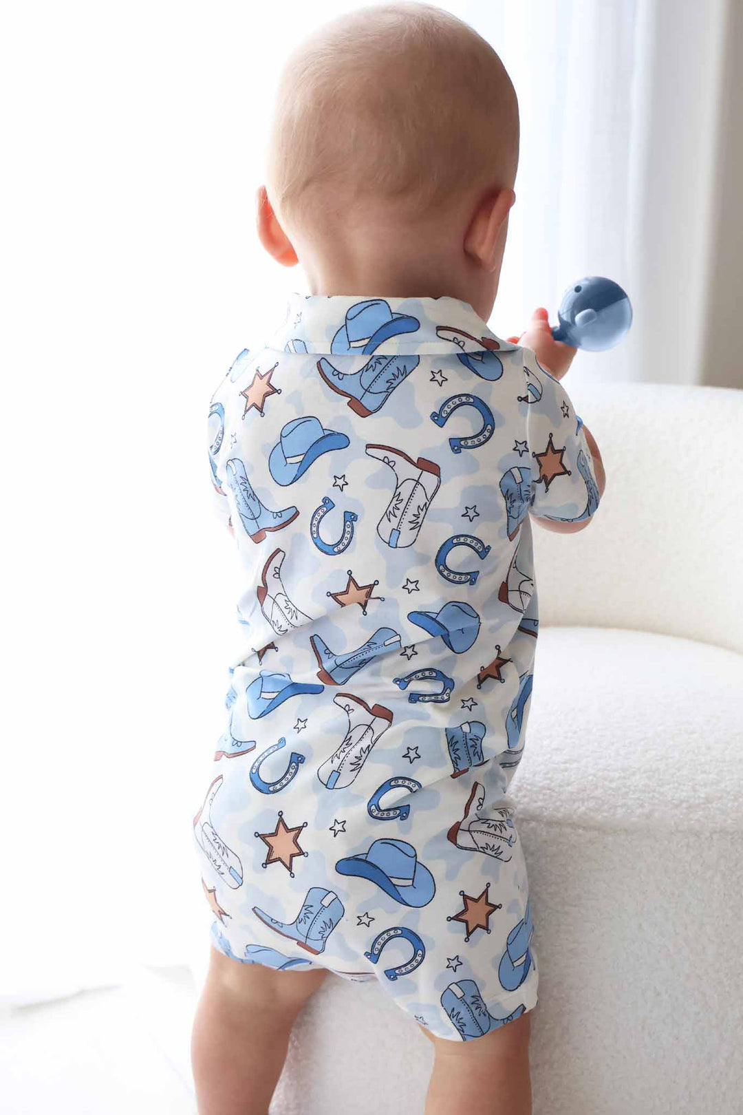 blue collared button up shorts romper with cowboy hats, boots, horseshoes and sheriff stars 