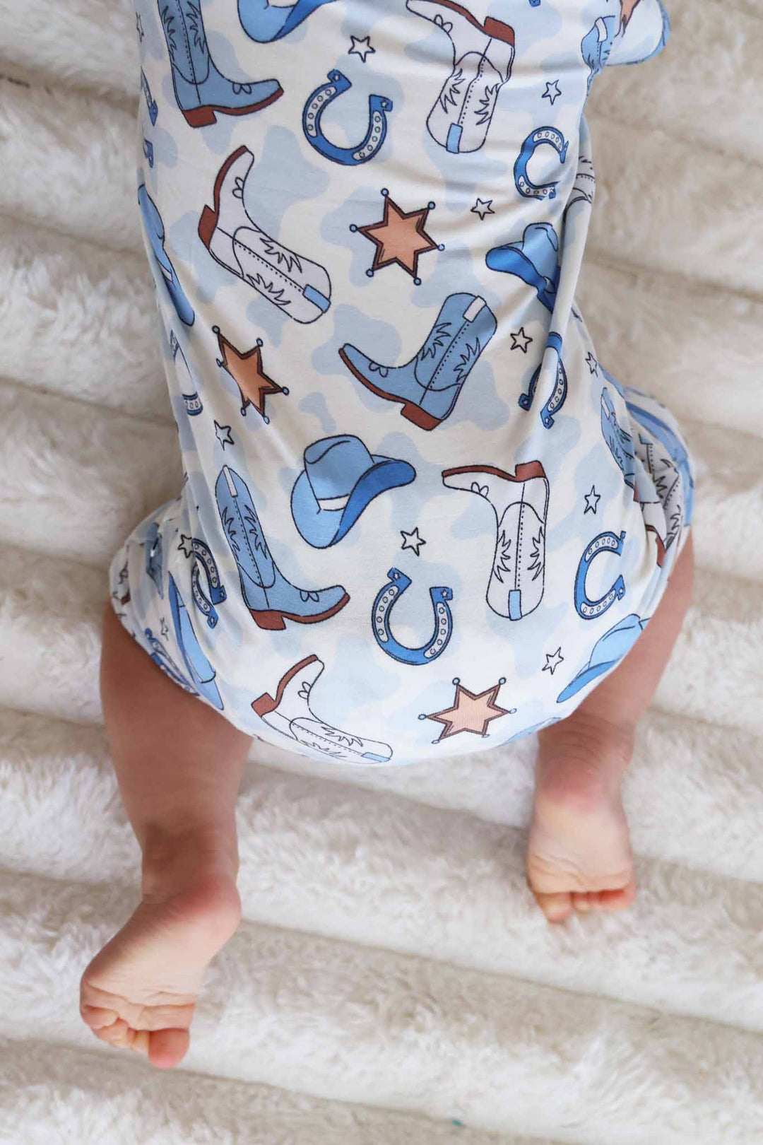 daytime romper for baby and toddler boys in blue cowboy print with hats, boots, horseshoes and sheriff stars 