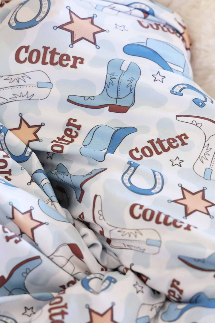 blue cowboy boot, hat, horseshoe and sheriff star personalized swaddle for newborn boys 