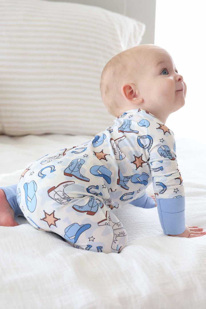crawling baby boy wearing a cowboy themed convertible zip romper 