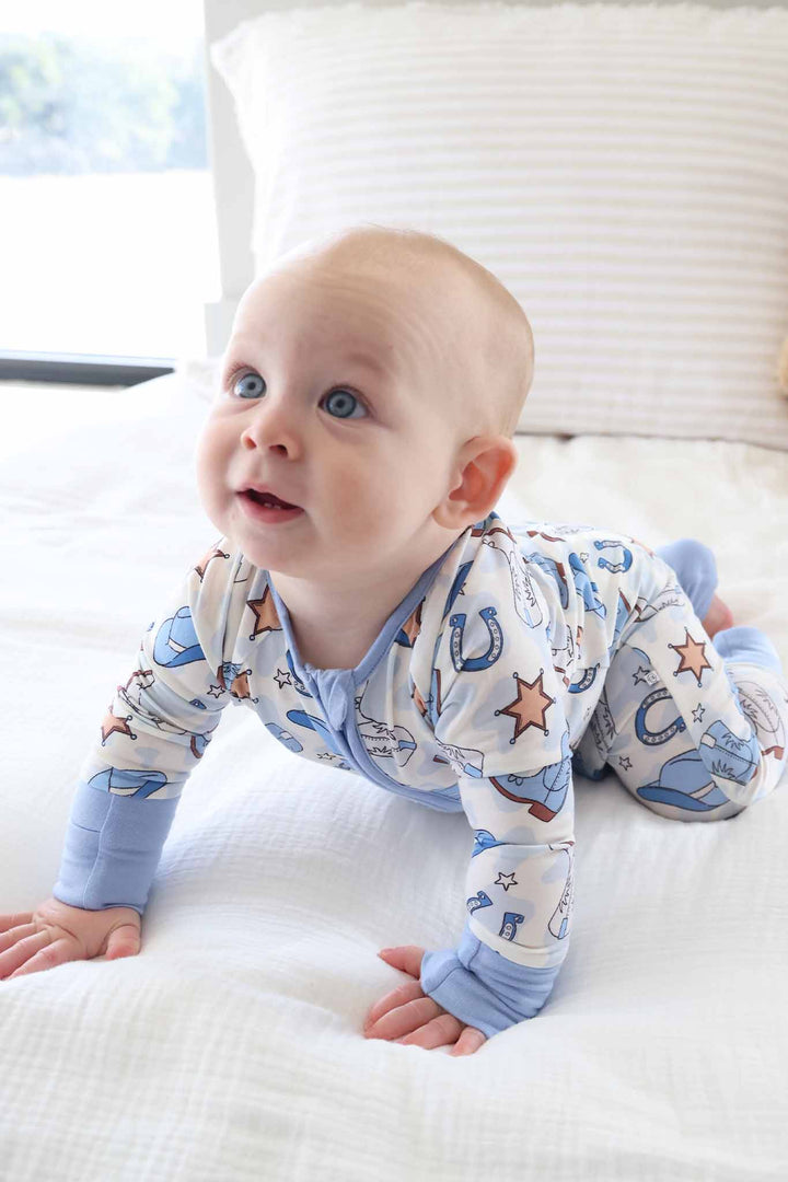 baby boy wearing cowboy themed pajama romper in blue 