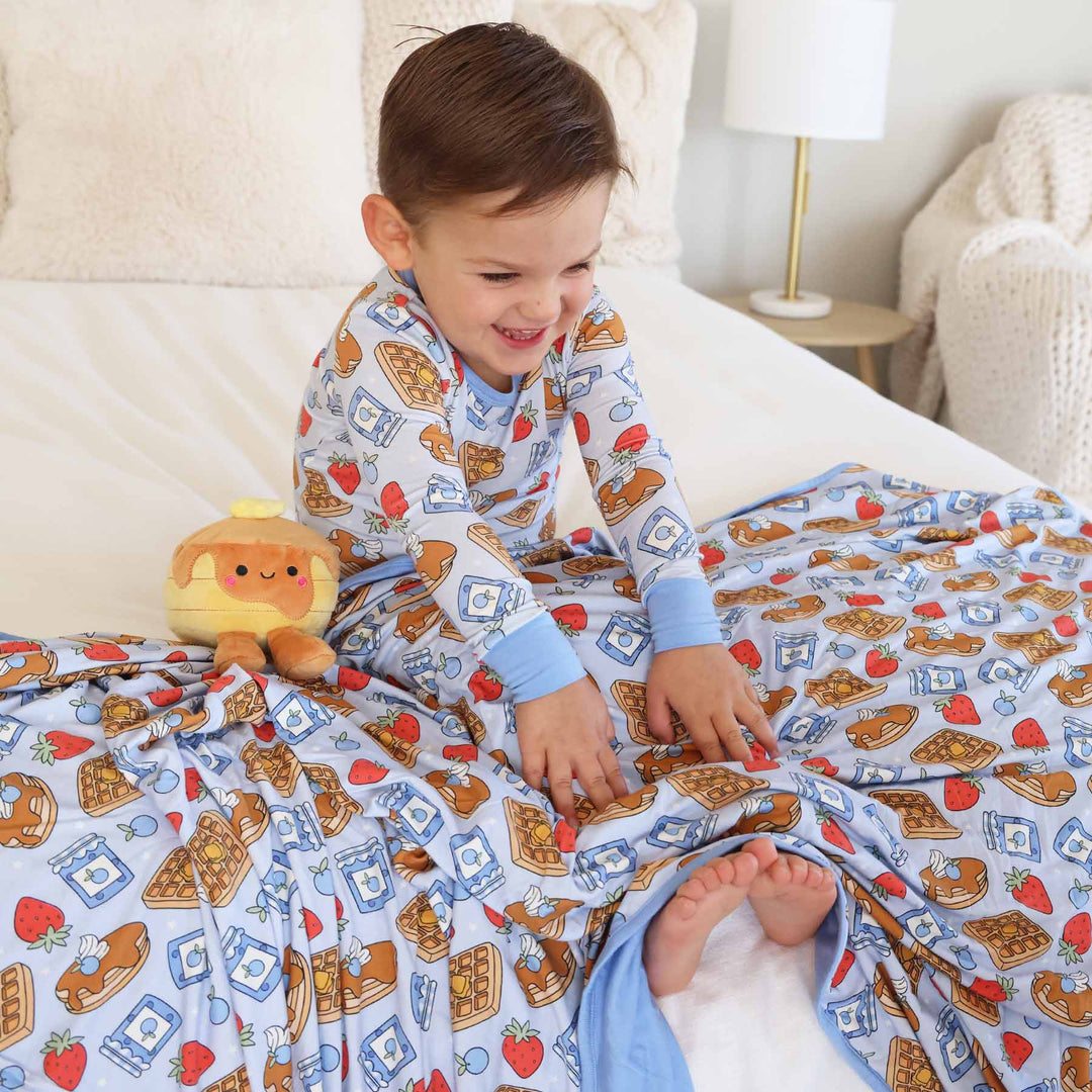 boy covered with sweet stacks blue double sided bamboo blanket with matching two piece pajama set
