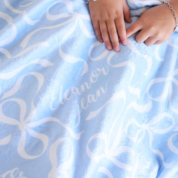 light blue personalized kids blanket with white bows 