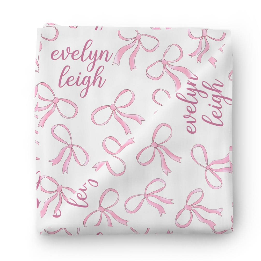 white personalized swaddle blanket with pink bows 