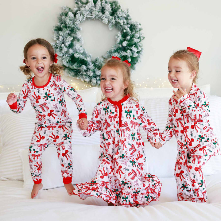 Little girl on the left wearing the Bow What Fun Two Piece Pajama Set. Little girl on the right wearing the Bow What Fun Two Piece Flare Lounge Set. 