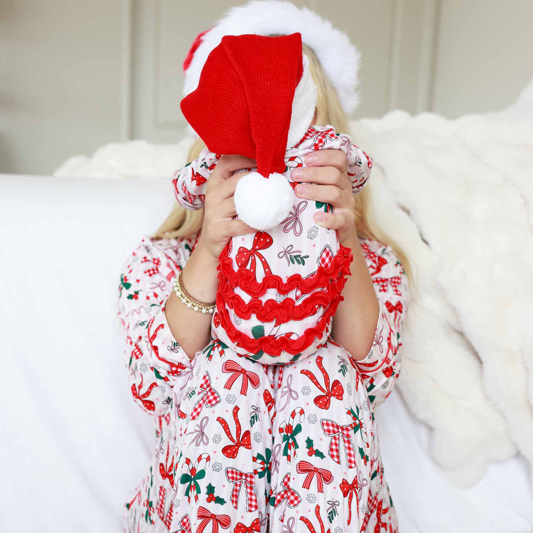 Back of the Baby wearing the Bow What Fun Ruffle Zipper Footie with a mini santa hat. 