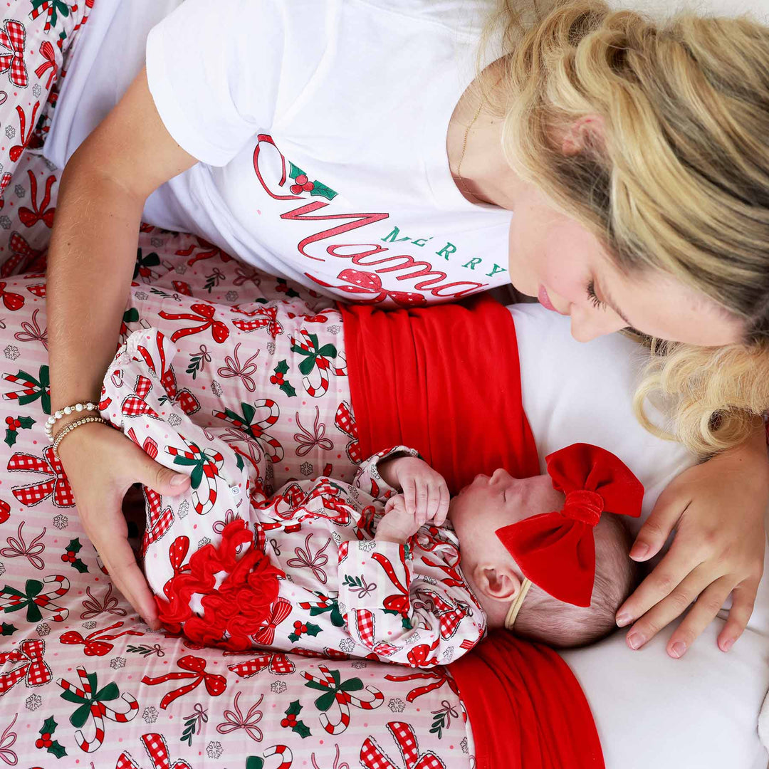 Baby wearing the Bow What Fun Ruffle Zipper Footie with bow and matching momma