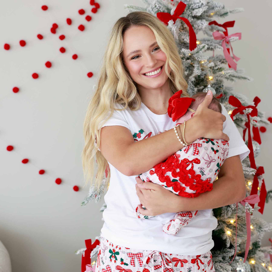 Baby wearing the Bow What Fun Ruffle Zipper Footie with bow and matching momma