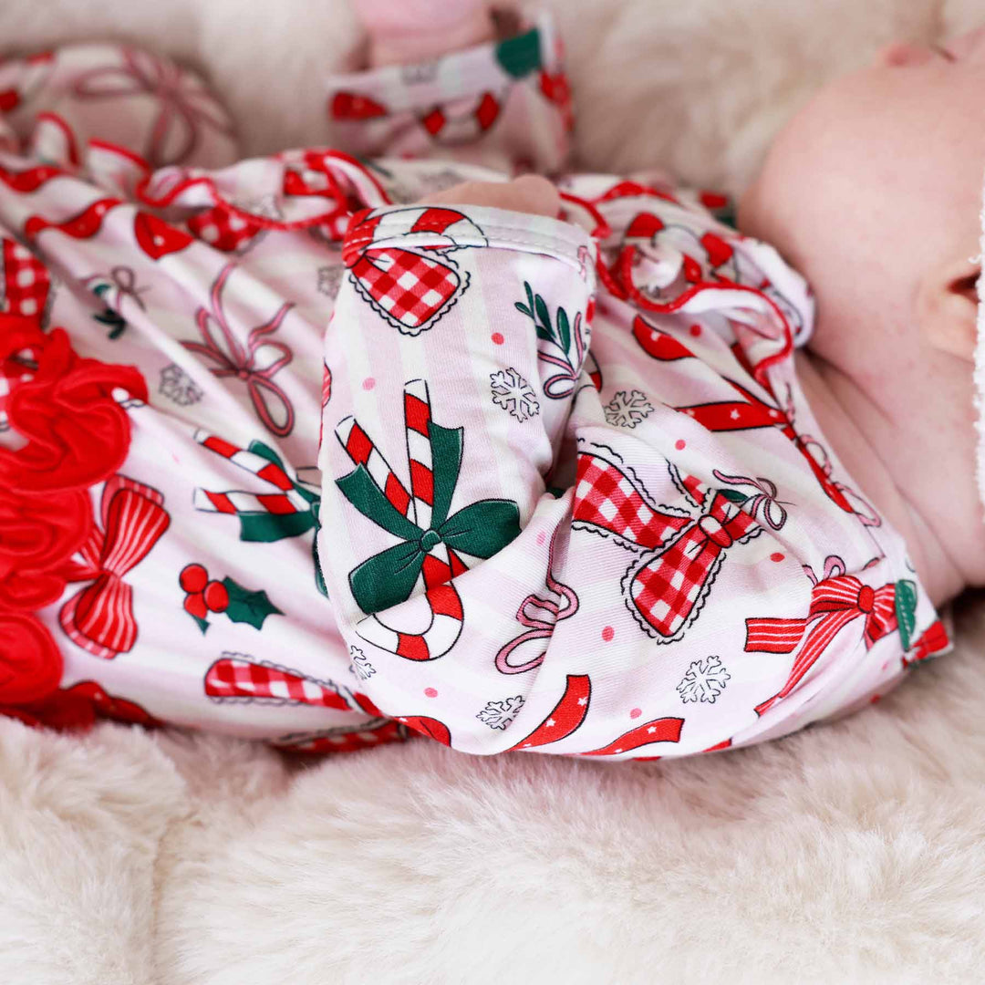 Close up of Baby wearing the Bow What Fun Ruffle Zipper Footie 