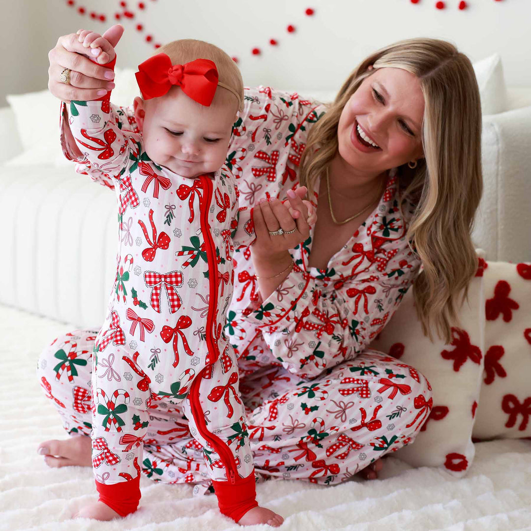 Baby wearing the Bow What Fun Convertible Zip Romper and matching mom with same pajama print