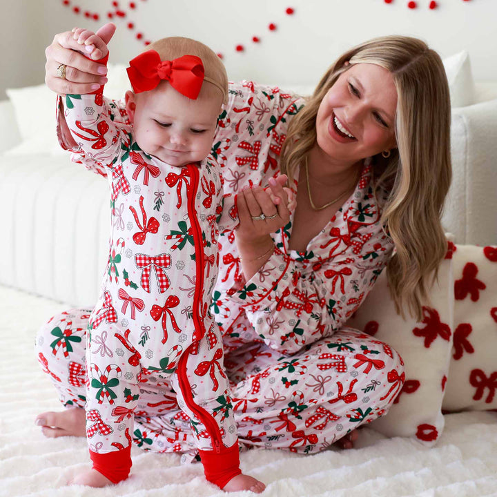 Baby wearing the Bow What Fun Convertible Zip Romper and matching mom with same pajama print