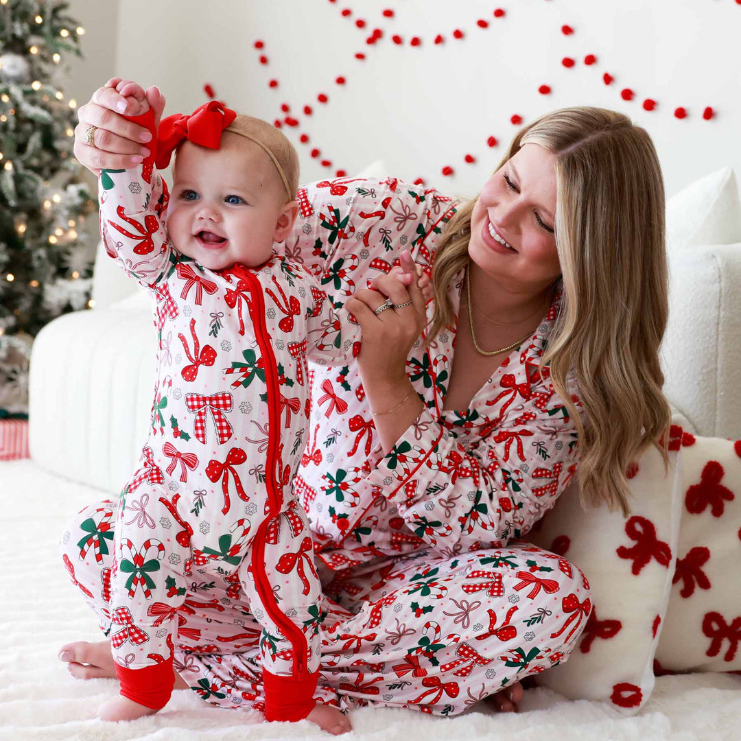 Baby wearing the Bow What Fun Convertible Zip Romper and matching mom with same pajama print
