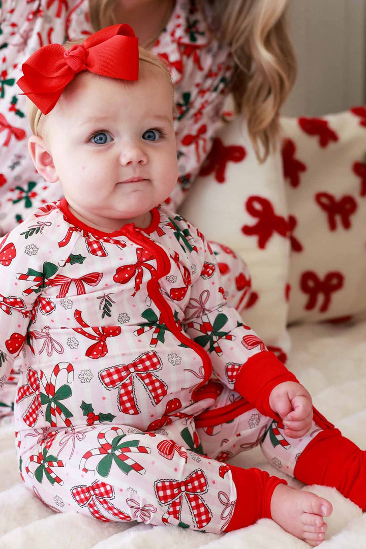 Baby and mom in red and green Caden Lane matching outfits with bows and candy canes