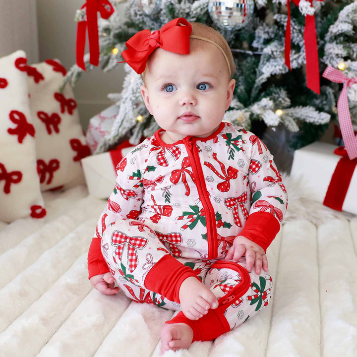 Baby wearing the scarlet ribbon bow headband for newborns Bow and  What Fun Convertible Zip Romper