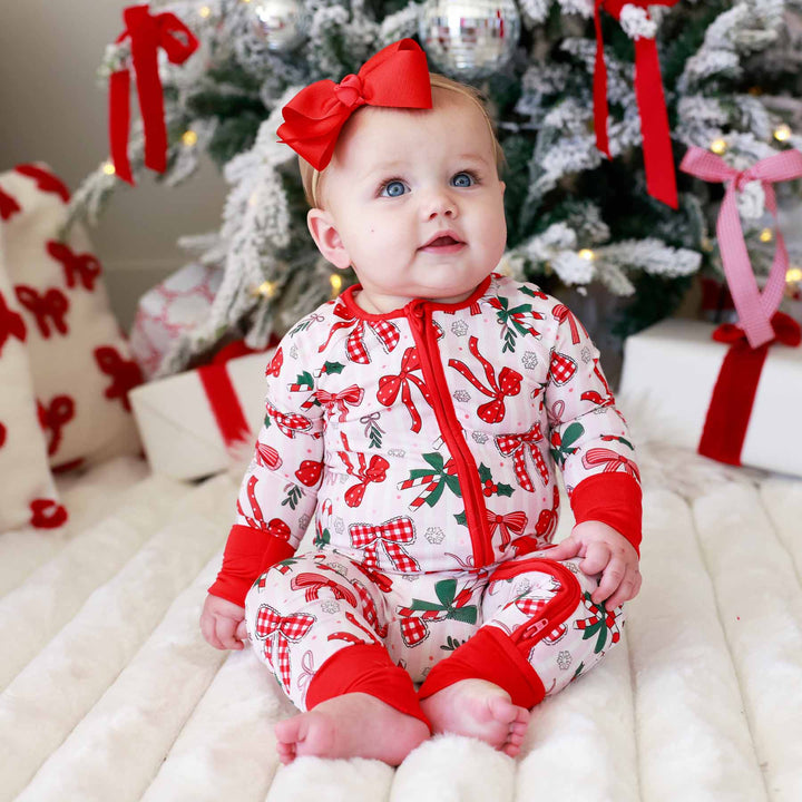 Baby wearing the scarlet ribbon bow headband for newborns Bow and  What Fun Convertible Zip Romper