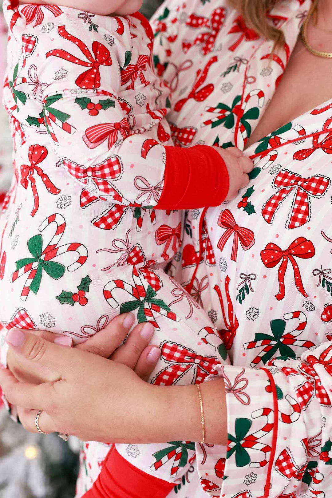 Baby and mom in red and green Caden Lane matching outfits with bows and candy canes