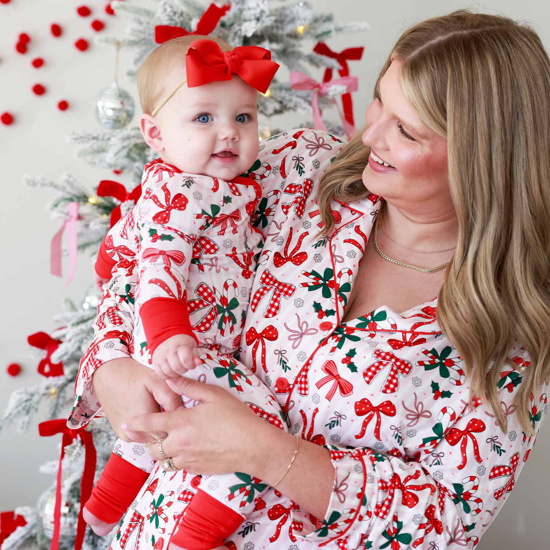 Baby wearing the scarlet ribbon bow headband for newborns Bow and  What Fun Convertible Zip Romper and matching momma with same print pajama set. 