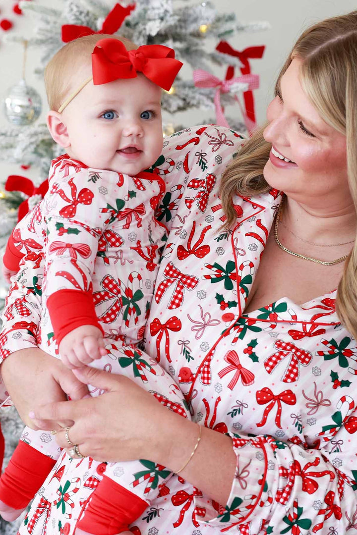 Baby and mom in red and green Caden Lane matching outfits with bows and candy canes