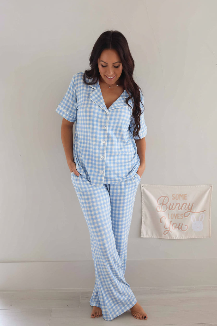 woman wearing a short sleeve collared pant lounge set in blue and white gingham 