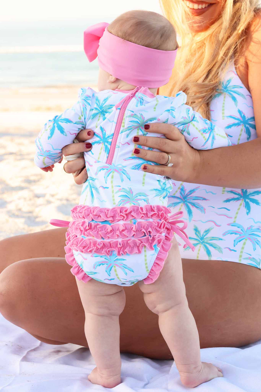 mom and daughter wearing matching swimsuits in neon palm tree print 