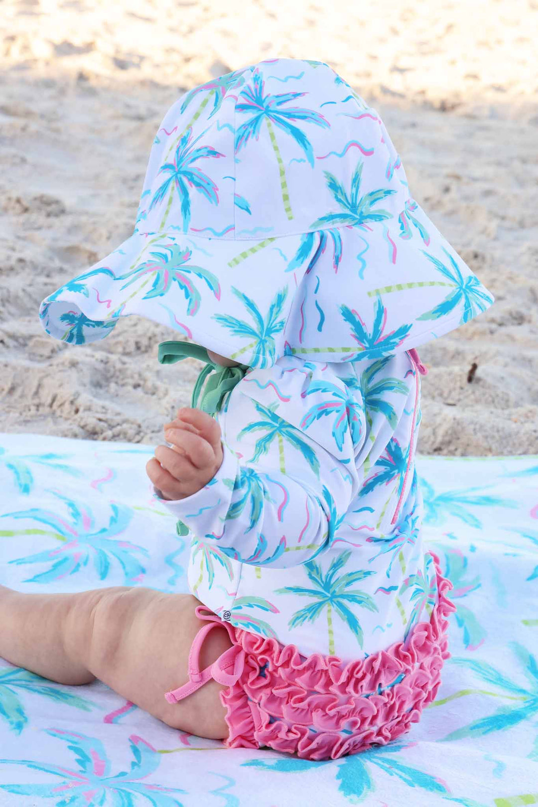 side view of blue lagoon long sleeve rash guard swim romper with ruffle bottom and matching sun hat 