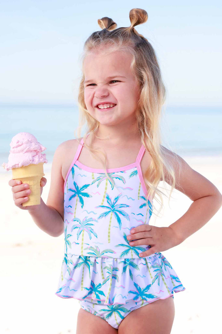 girl standing on beach in blue lagoon tankini holding an ice cream