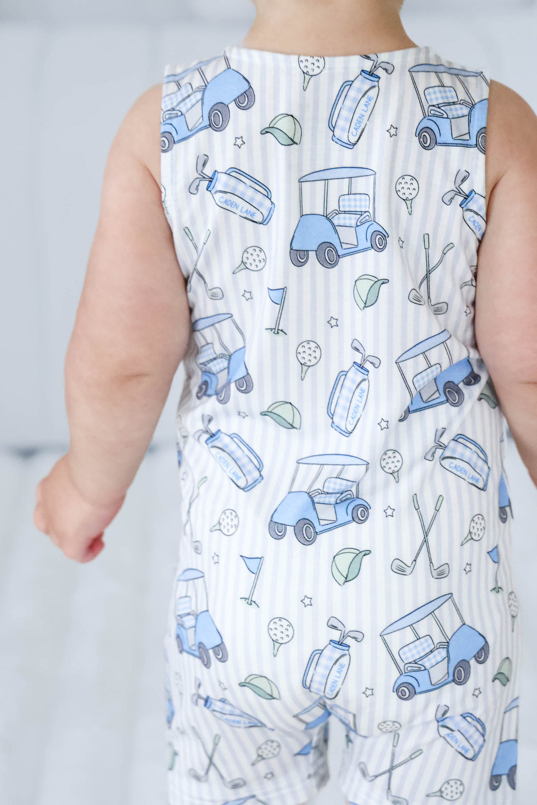 back view of caddie crew blue sleeveless snap romper for boys