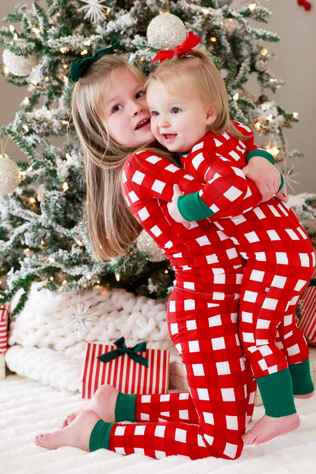 Sisters in red, green, and white plaid Caden Lane pajamas