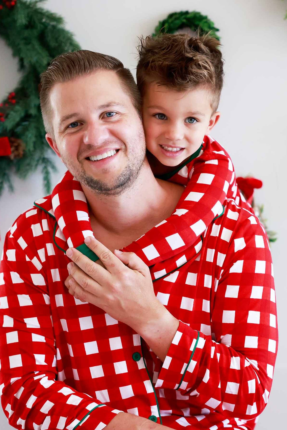 Father and son in red, green, and white plaid Caden Lane pajamas