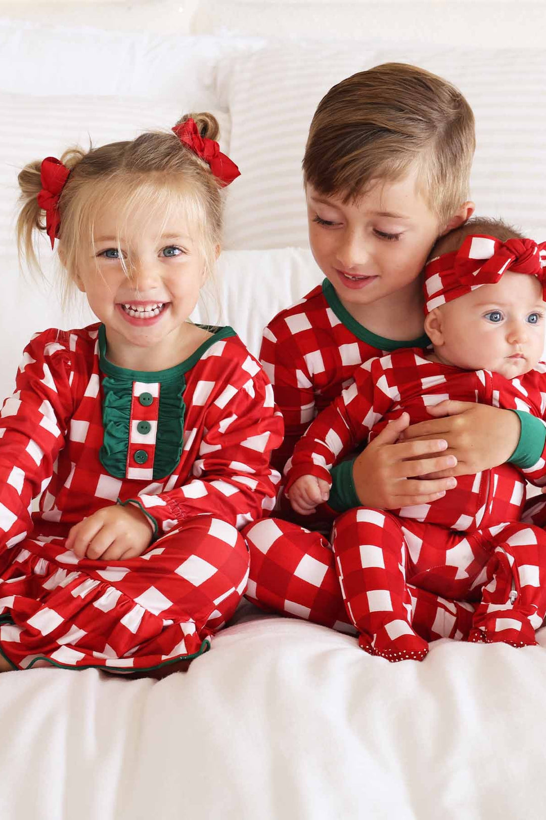 Siblings in red, green, and white plaid Caden Lane pajamas