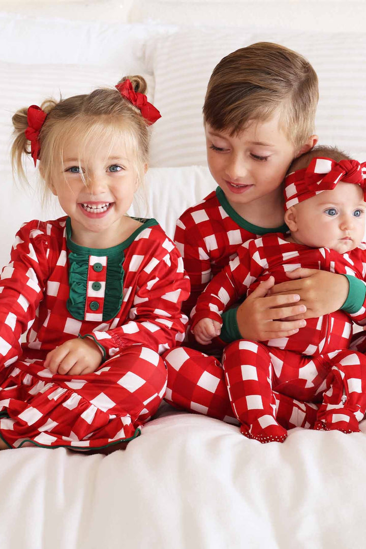 Siblings in red, green, and white plaid Caden Lane pajamas