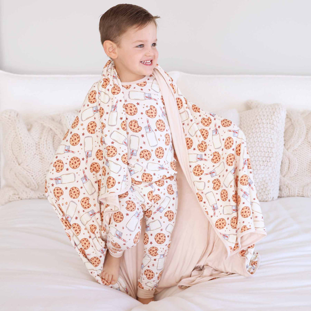 blanket for kids made of bamboo with a neutral milk and cookies print 