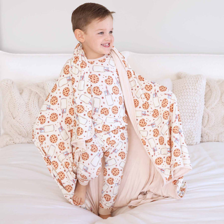 blanket for kids made of bamboo with a neutral milk and cookies print 