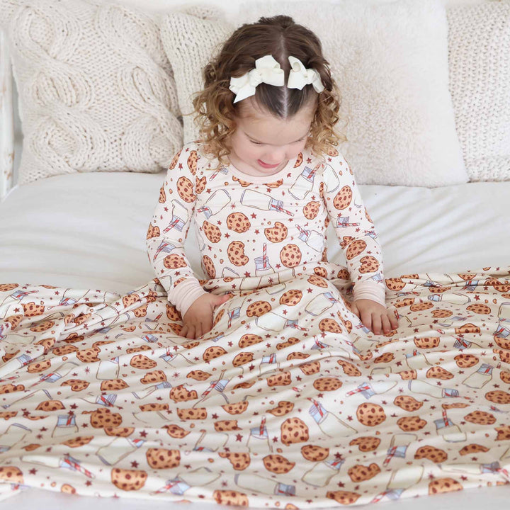 girl covered with milk and cookies neutral bamboo blanket wearing two piece pajama set 
