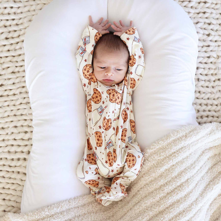 baby laying in lounger with a milk and cookies zipper footie pajama