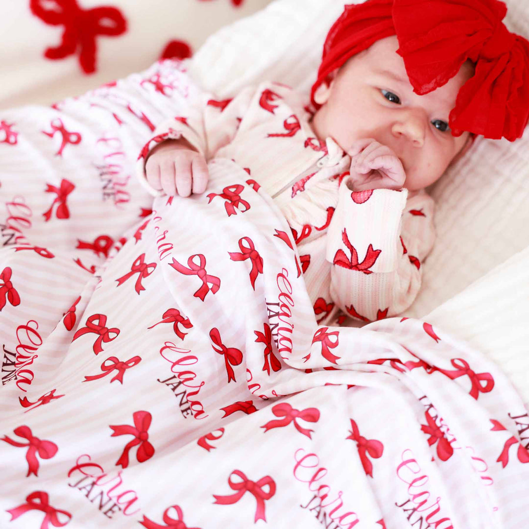 coquette christmas personalized swaddle blanket for girls pink and white stripe and red bow 