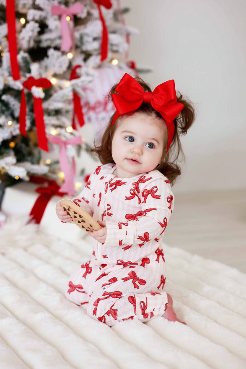 christmas convertible zip romper pajama for babies and toddlers pink and white stripes with red bows 