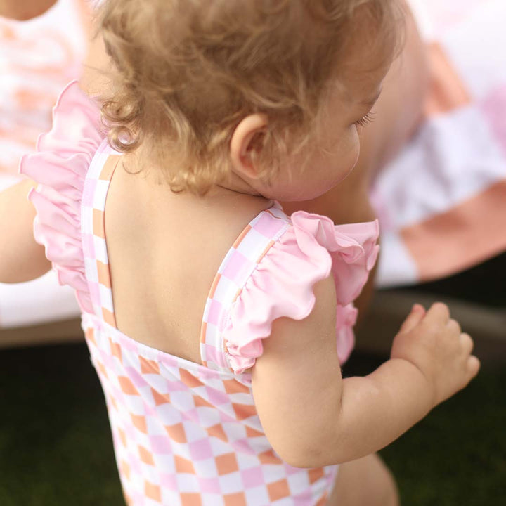 orange and pink checkered print one piece with pink ruffle