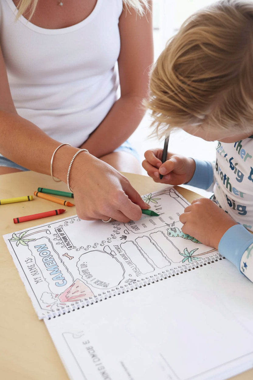 Adult and child coloring together on a personalized 'My Name Is Cameron' profile activity page featuring a watermelon slice and dinosaur illustrations in a Caden Lane coloring book.