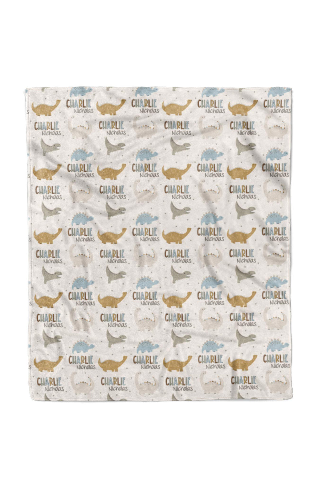 Flat lay of a fully unfolded personalized Caden Lane Dino Stomps blanket in cream, showing the full repeating pattern of dinosaur silhouettes and custom name